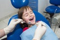 A close-up of a dentistÃ¢â¬â¢s hands and a child with an opened mouth